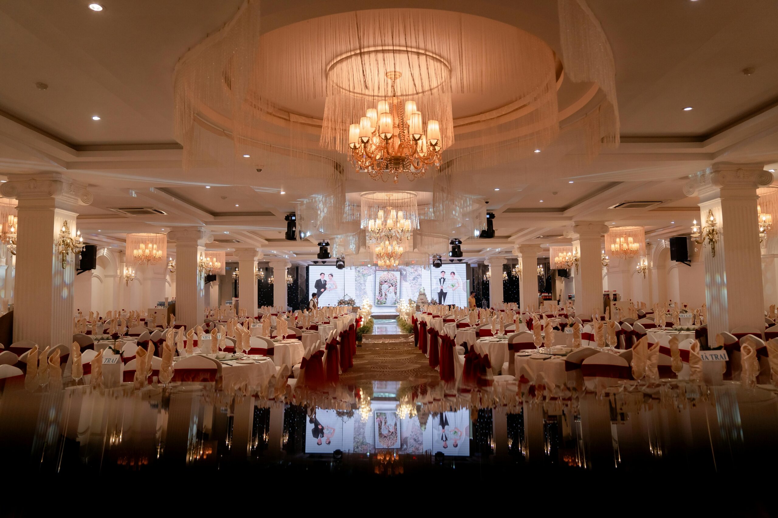 Elegant wedding venue rental ballroom setup with chandeliers and reception tables in Houston